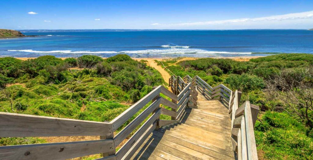 Wooden steps leading down to bright beach on a summer day